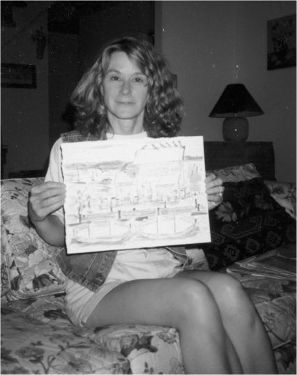 A woman holding up artwork.