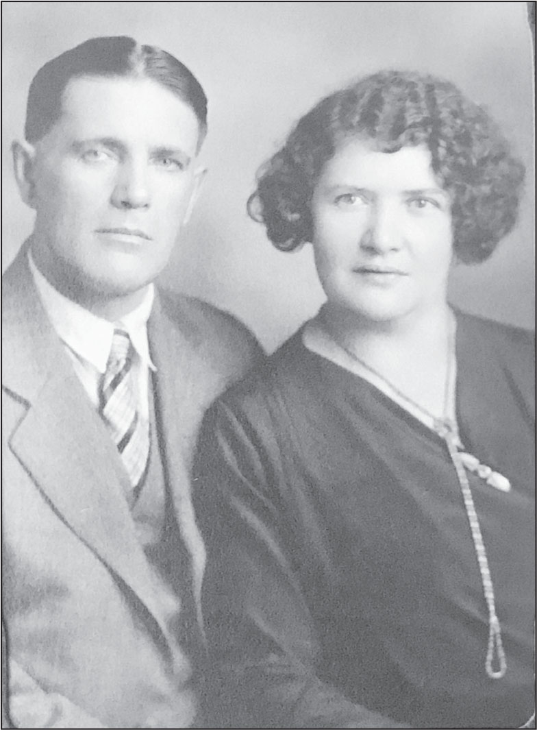A black-and-white photo of a young white man in a suit and a striped tie and a young white woman with a short wavy bobb hair in a dark blouse and necklace.